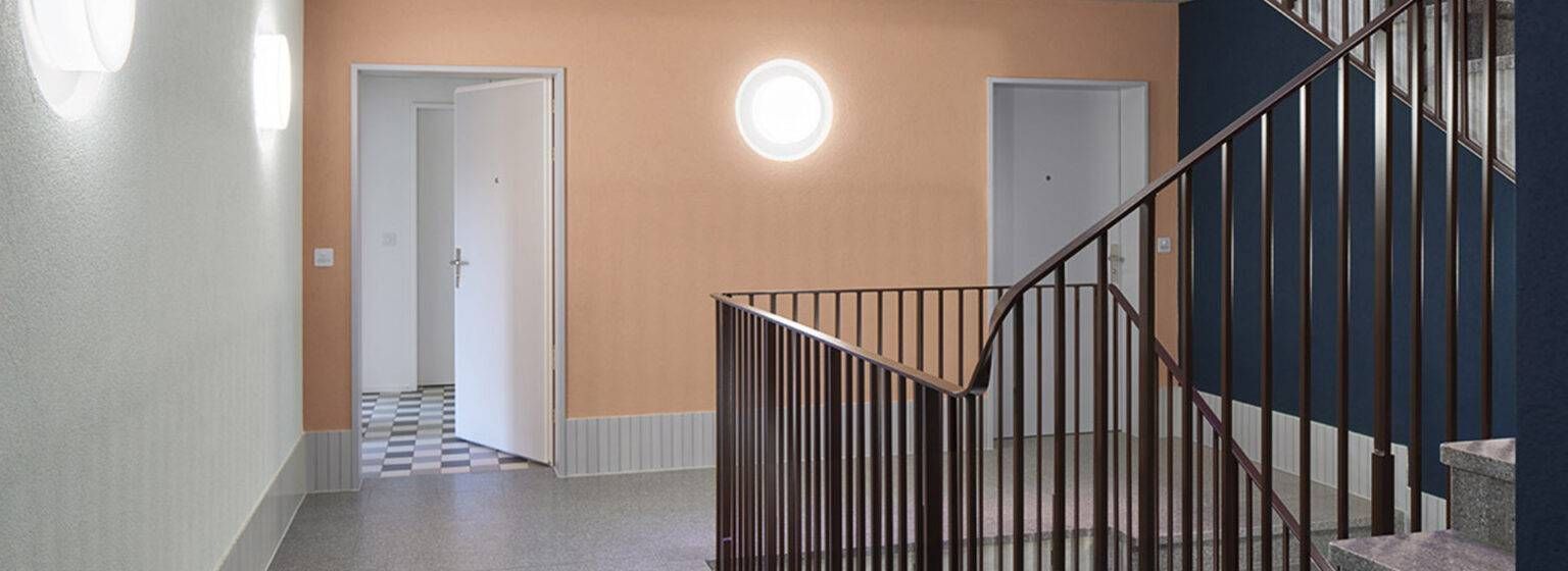 Ein Flur mit einer Treppe und einer Lampe an der Wand. Foto von der Benardi Malergeschäft GmbH