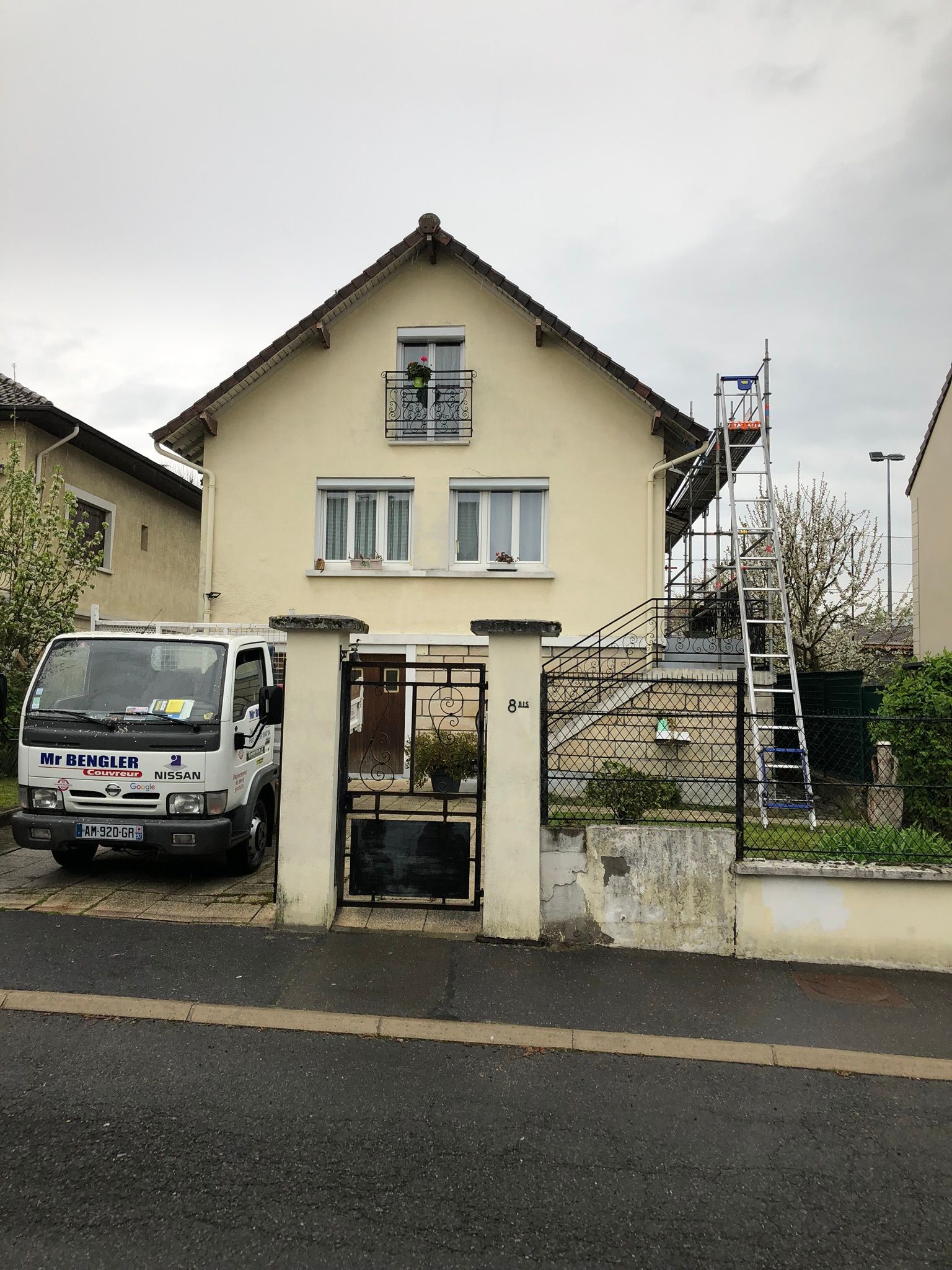 Camionnette de couvreur garée devant une maison avec échafaudage