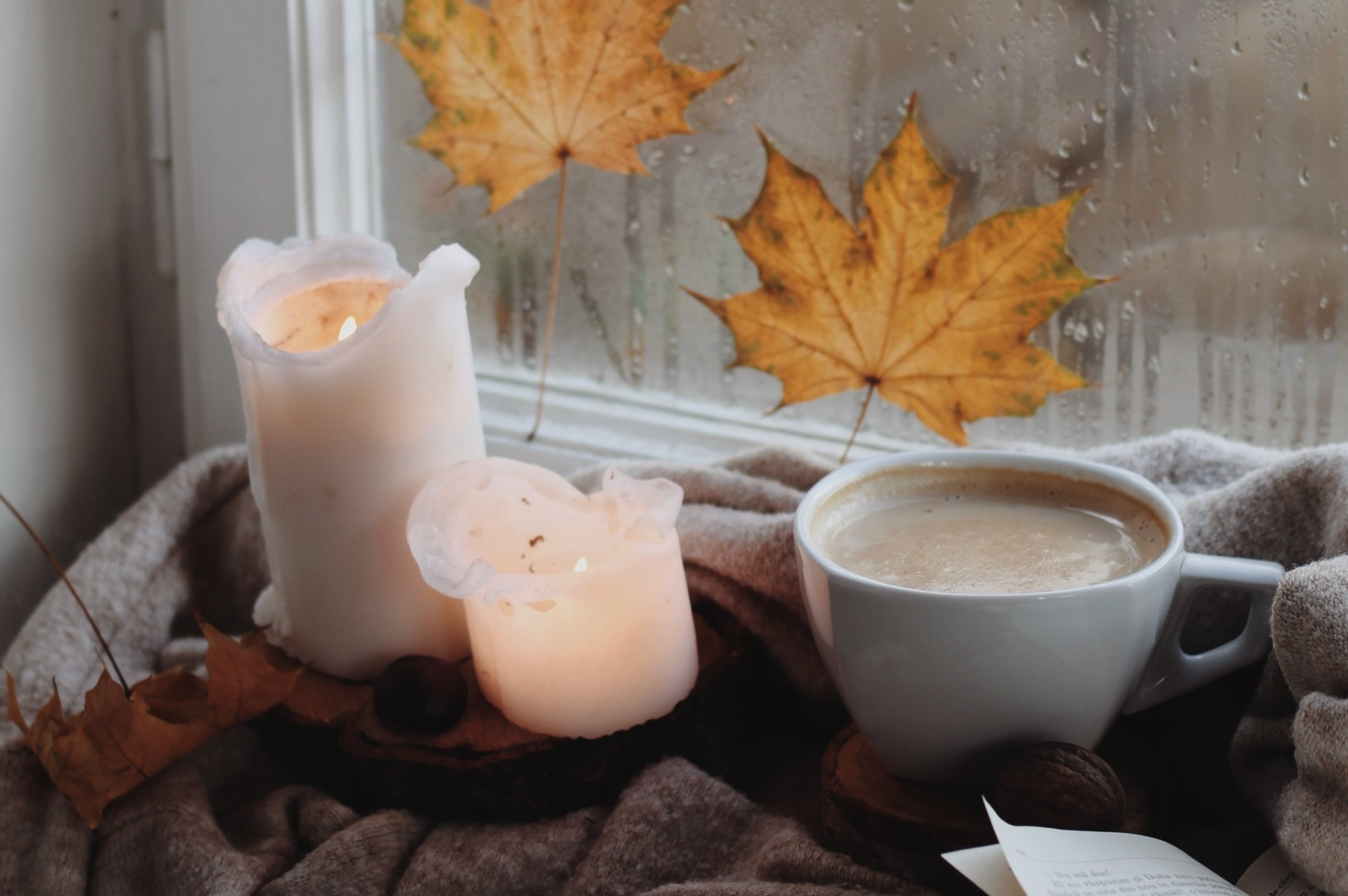 Bougie et tasse de café devant la fenêtre