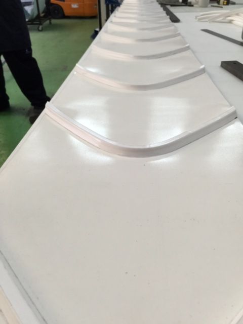 Un primer plano de una cinta transportadora blanca en una fábrica.