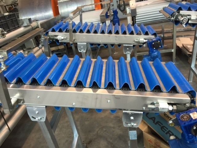 Una cinta transportadora de acero inoxidable con rodillos de goma azules