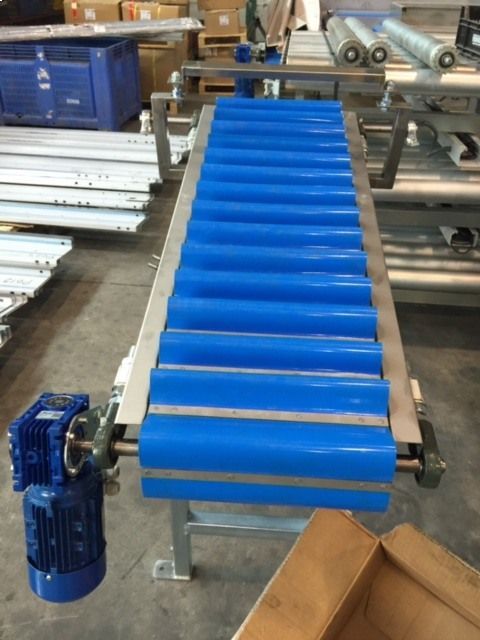 Una cinta transportadora con rodillos azules y un motor conectado a ella.