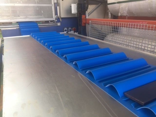 Una cinta transportadora con tubos azules.