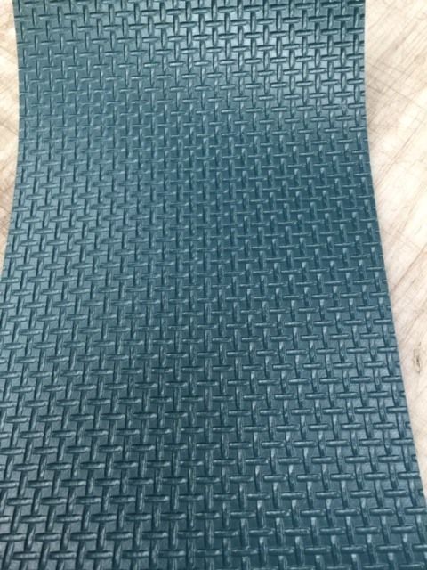 Un primer plano de una alfombra verde con un patrón.