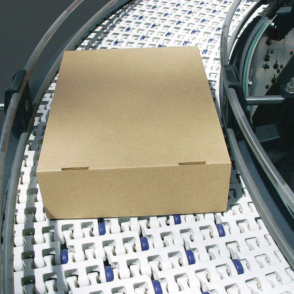 Una caja de cartón está sobre una cinta transportadora.
