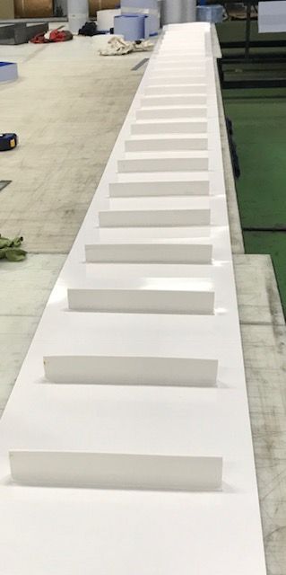 Una larga escalera blanca reposa sobre una mesa en una habitación.