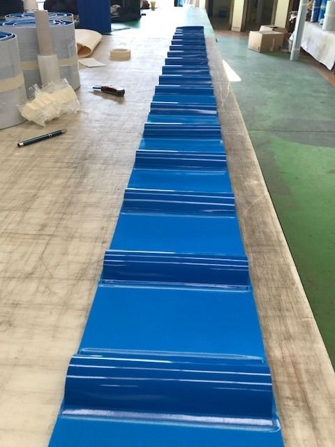 Una fila de sábanas azules están alineadas sobre una mesa.