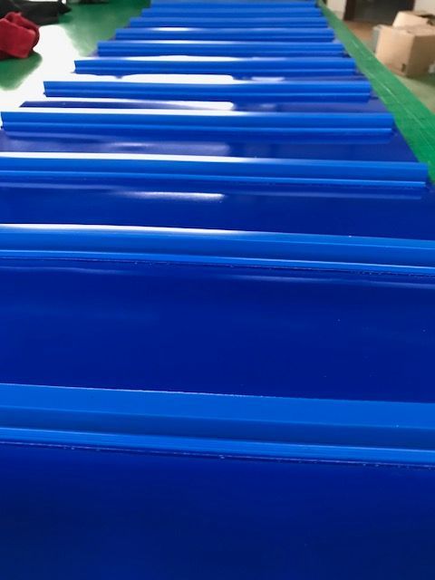 Una cinta transportadora azul está colocada encima de una mesa verde.