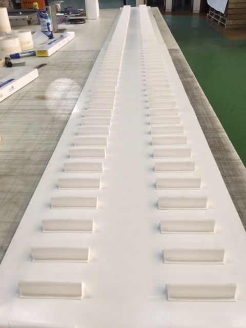 Una cinta transportadora blanca está colocada encima de una mesa.