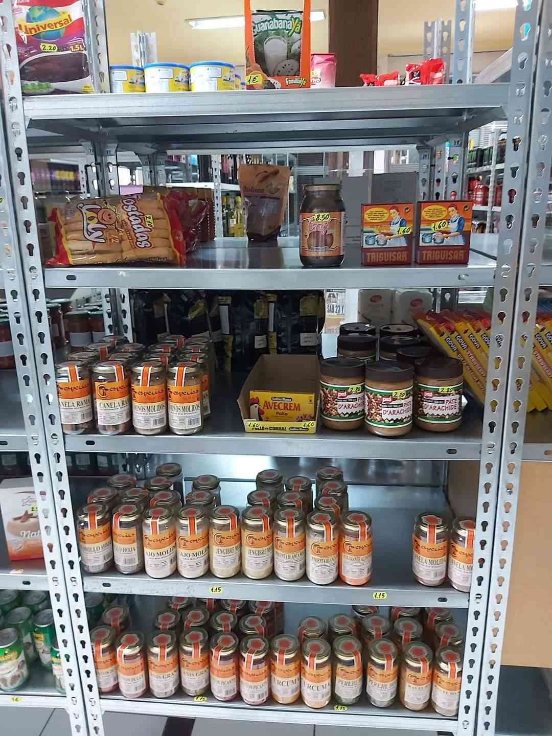 Estantería de la tienda repleta de tarros, botellas y alimentos envasados ​​de diversos tipos, principalmente salsas y condimentos.