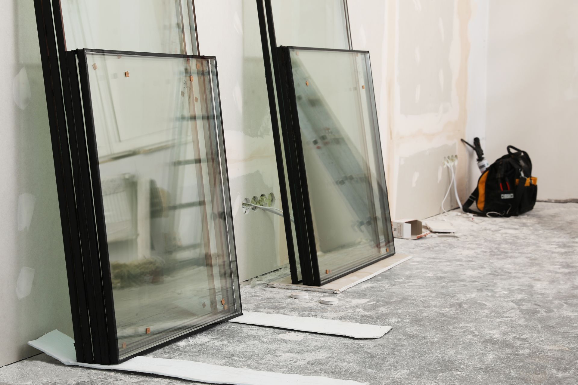 Des vitres appuyées contre un mur.
