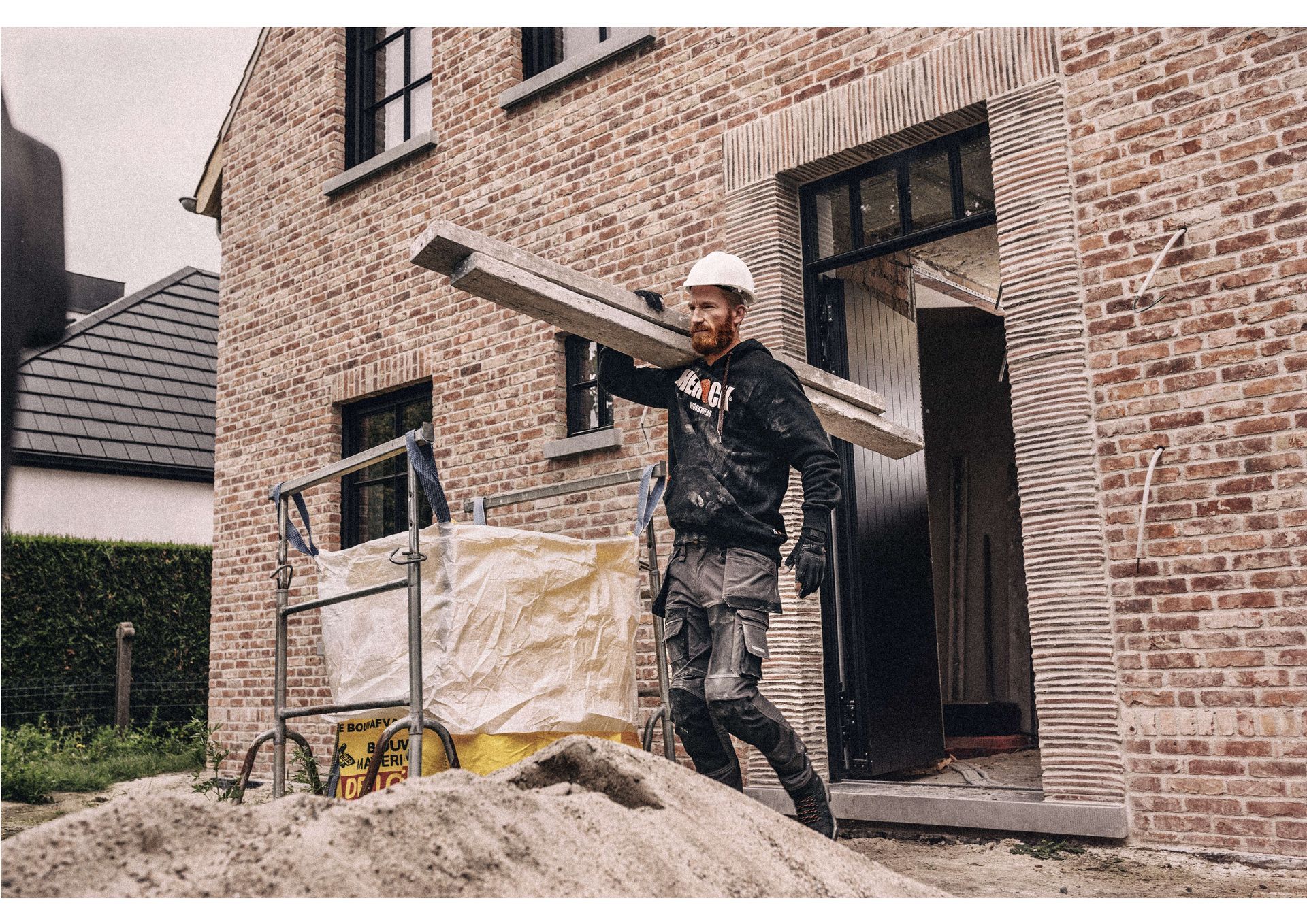 Ouvrier BTP portant des planches de bois