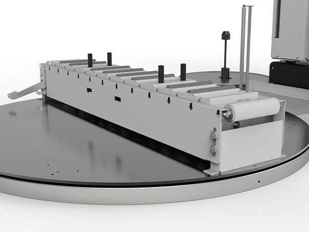 Machine industrielle sur un plateau tournant, avec rails métalliques et panneaux blancs, dans un atelier gris.