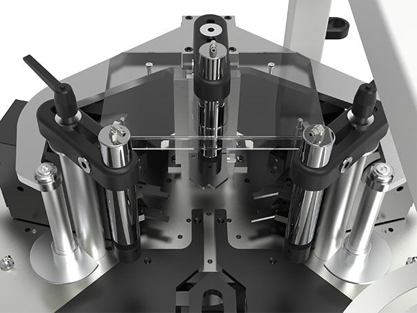 Gros plan sur une machine industrielle métallique avec des composants noirs et des panneaux de protection transparents