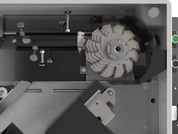 À l'intérieur du compartiment de la machine, on aperçoit une lame de coupe circulaire et des mécanismes métalliques.