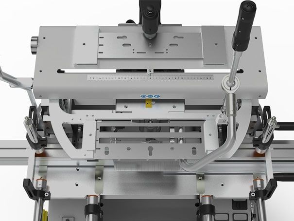 Machine industrielle grise avec leviers et commandes, vue de dessus.
