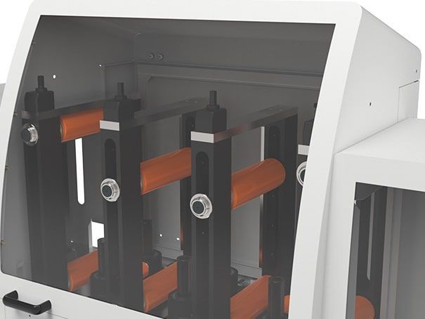 Intérieur d'une machine industrielle avec rouleaux orange et cadres noirs à l'intérieur d'un boîtier blanc