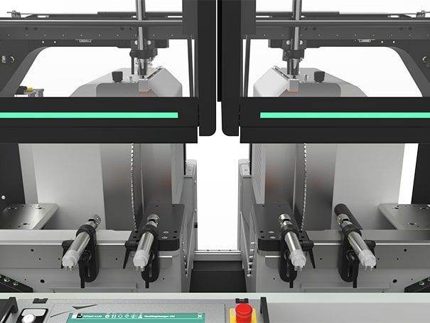 Deux machines industrielles noires et grises à effet miroir, avec des bandes lumineuses turquoise, à l'intérieur d'un boîtier métallique.