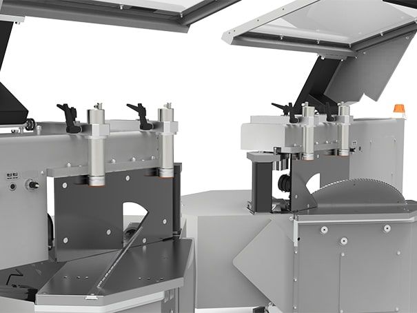 Deux machines industrielles grises, couvercles et panneaux de commande ouverts, sont présentées côte à côte dans un atelier.