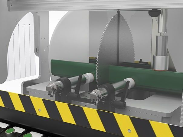 Machine industrielle avec des convoyeurs verts et des lames de scie circulaires derrière une barrière de sécurité noire et jaune.