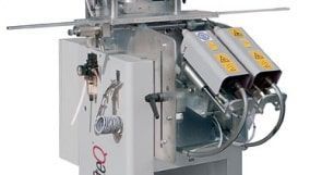 Machine industrielle avec boîtier en acier inoxydable, tuyaux et goulottes métalliques inclinées dans un environnement d'atelier