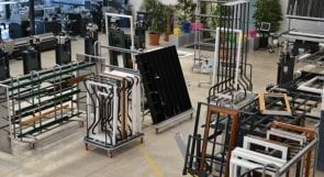 Atelier industriel avec des structures métalliques, des panneaux et des équipements disposés sur un sol d'usine.