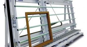 Machine industrielle avec rails métalliques et un cadre en bois appuyé contre elle