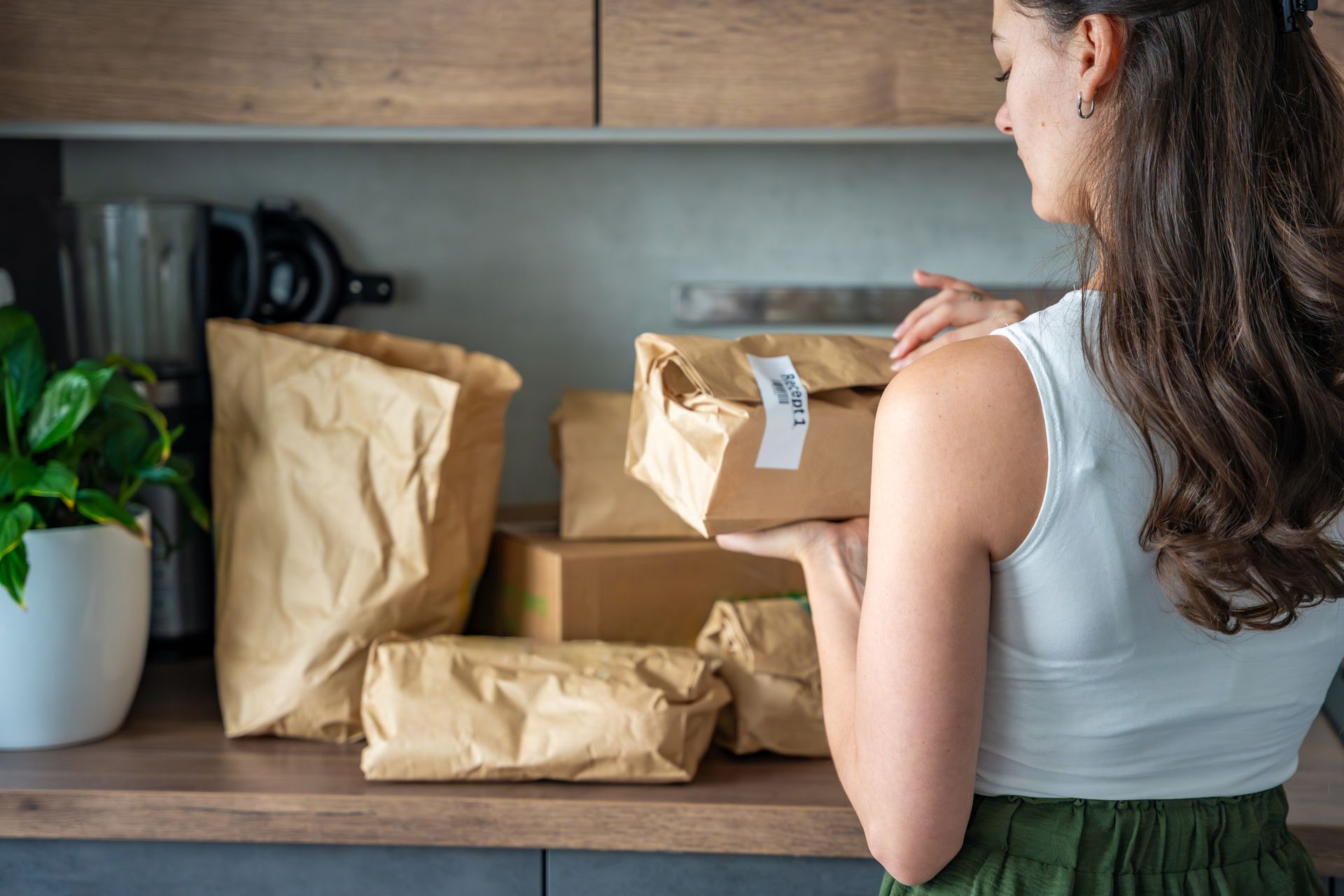 Une femme inspecte un sac en papier.