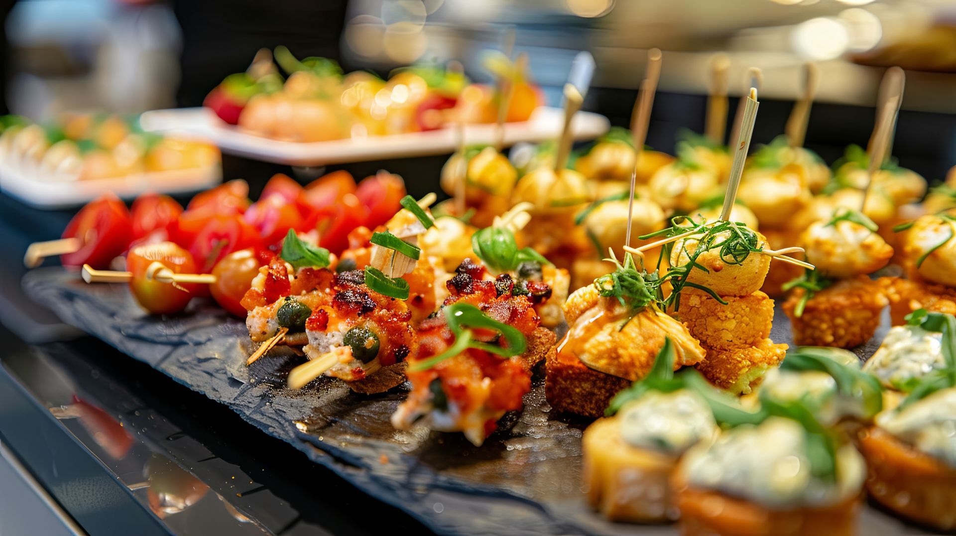 Des petites brochettes sur un plateau en ardoise.