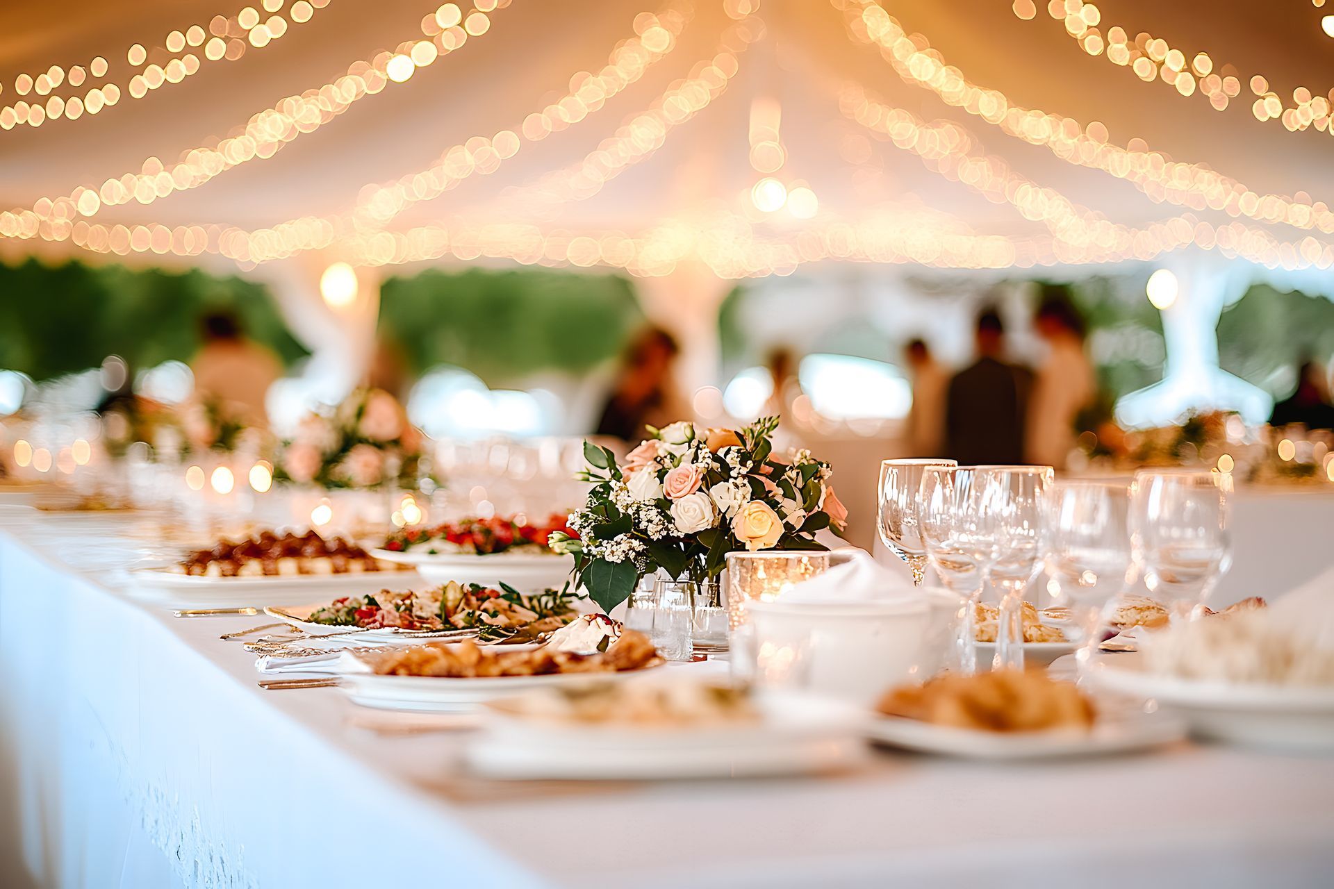 Un bouquet de fleurs, des assiettes et des verres sur une table.