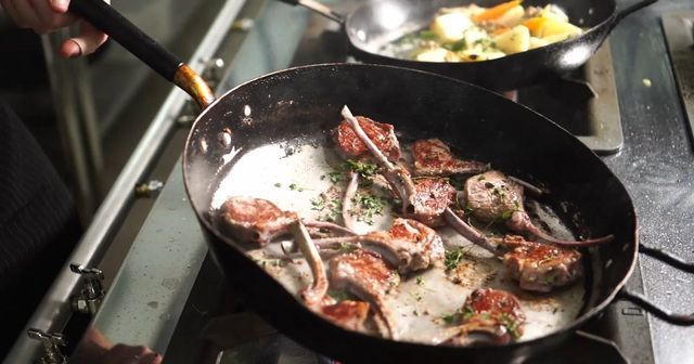 Des côtelettes d'agneau dans une poêle.