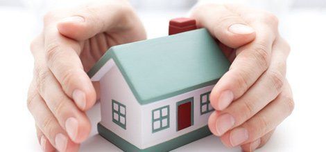 Una persona sostiene en sus manos una pequeña maqueta de casa.