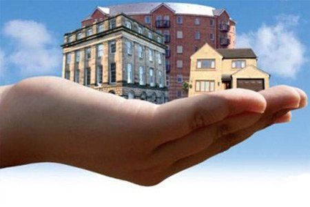 Una persona sostiene dos edificios en su mano.