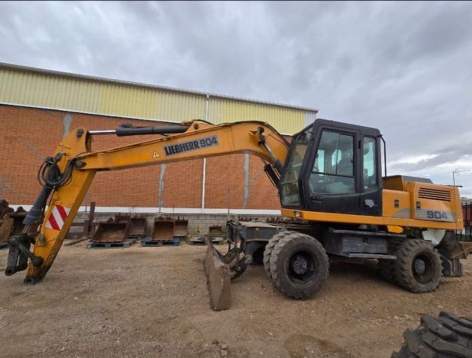 Excavadora de ruedas Liebherr 904 amarilla en un terreno de grava.