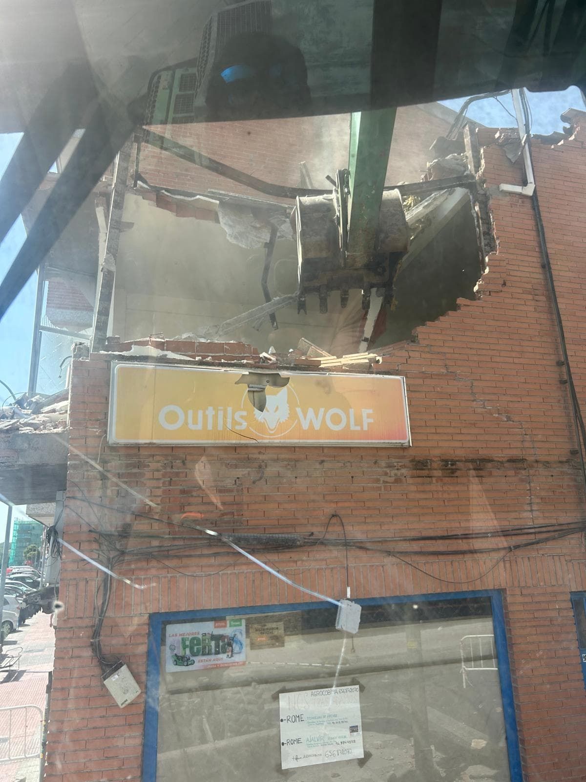 Demolición de un edificio de ladrillos con un cartel que dice