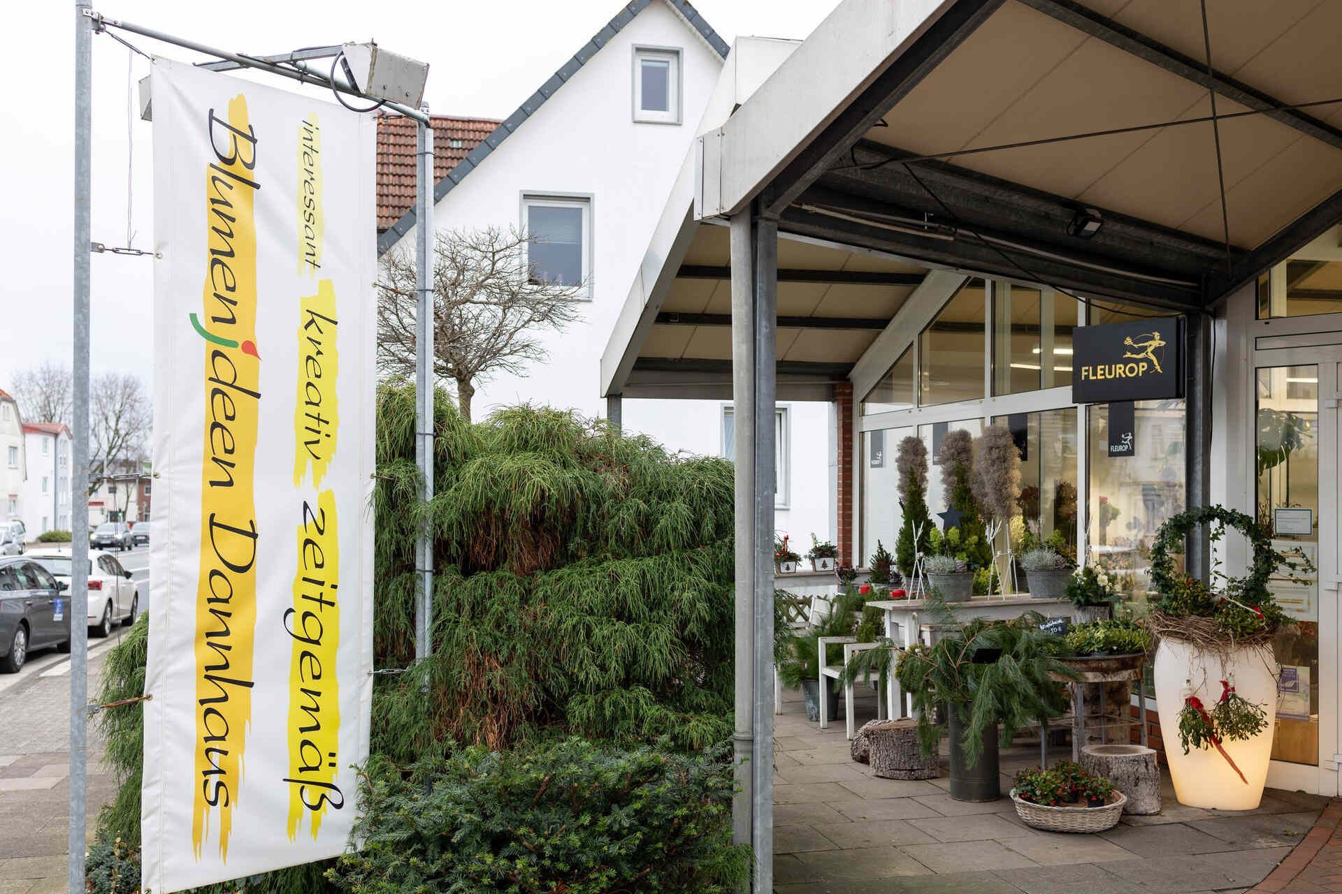 Eine Ladenfront mit einem Schild mit der Aufschrift „Blumenladen“ darauf