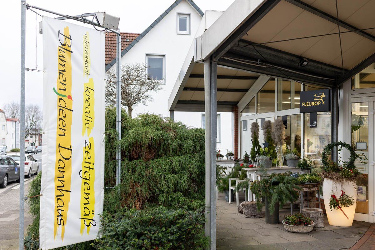 Ein weißes Gebäude mit einem Schild mit der Aufschrift „Blumenladen“ darauf