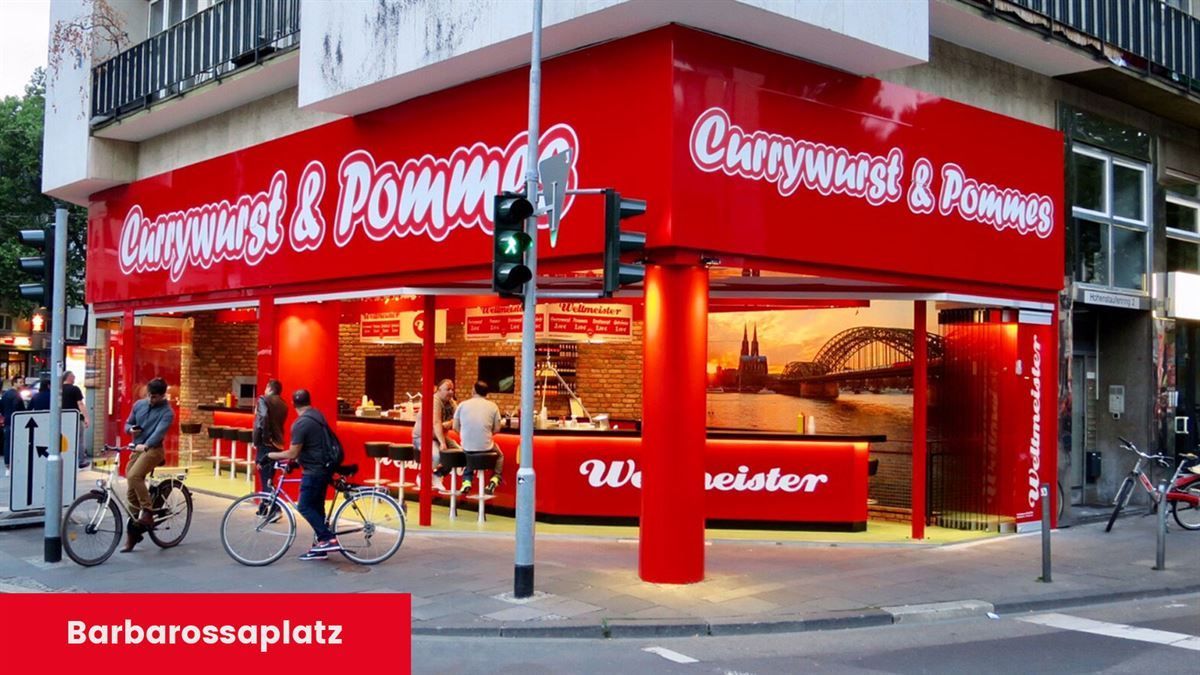 Ein rotes Gebäude mit einem Schild mit der Aufschrift „Barbarossaplatz“