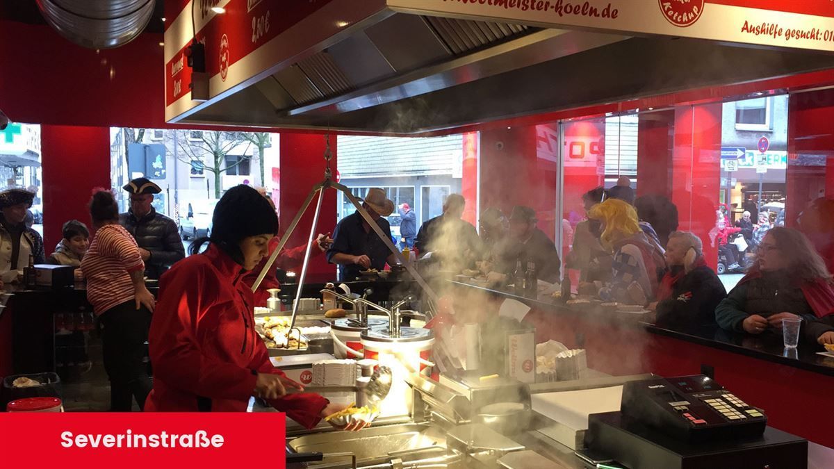 Eine Frau in einer roten Jacke bereitet in einem Restaurant Essen zu