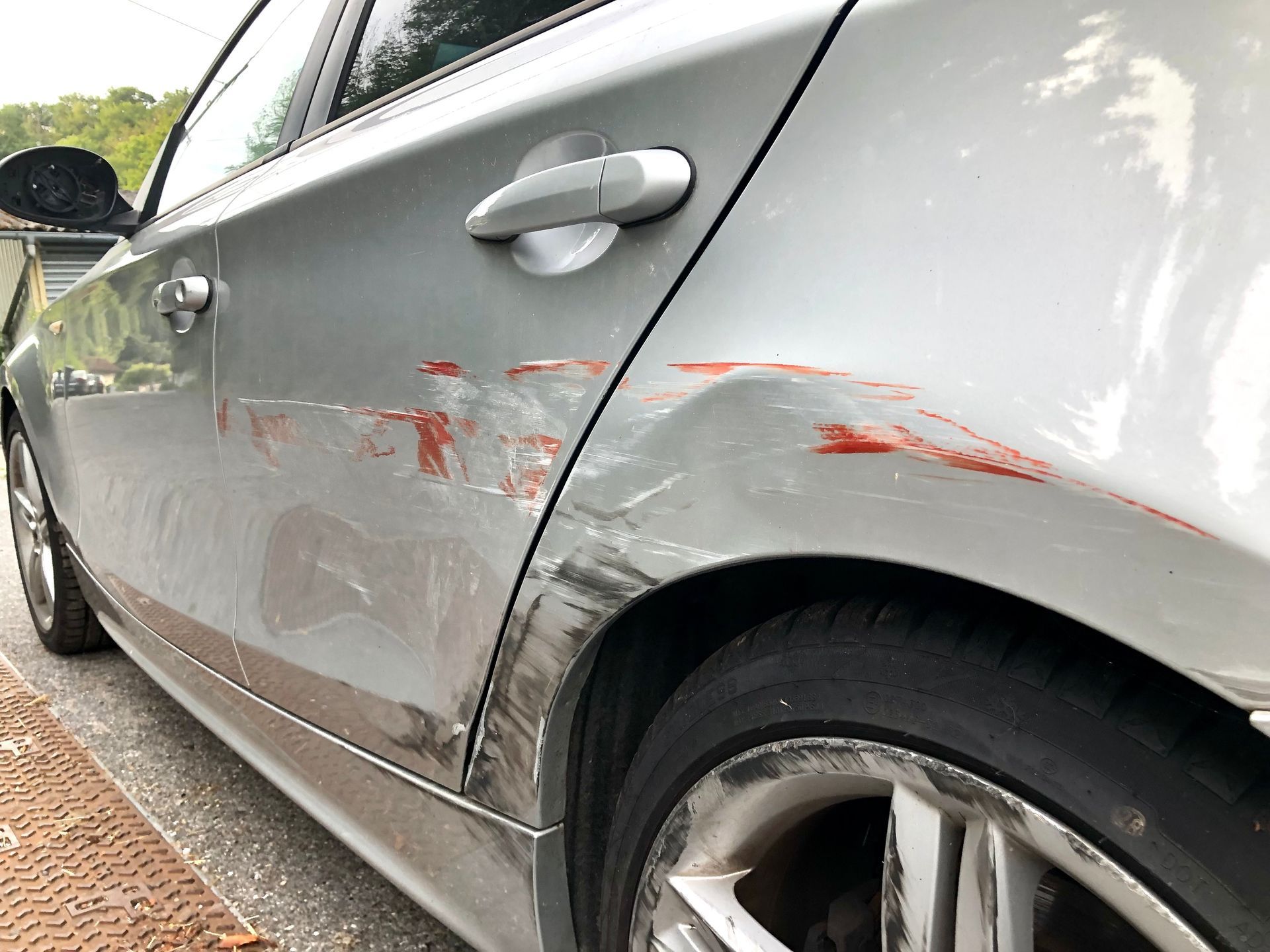 Rayures rouges sur une carrosserie grise