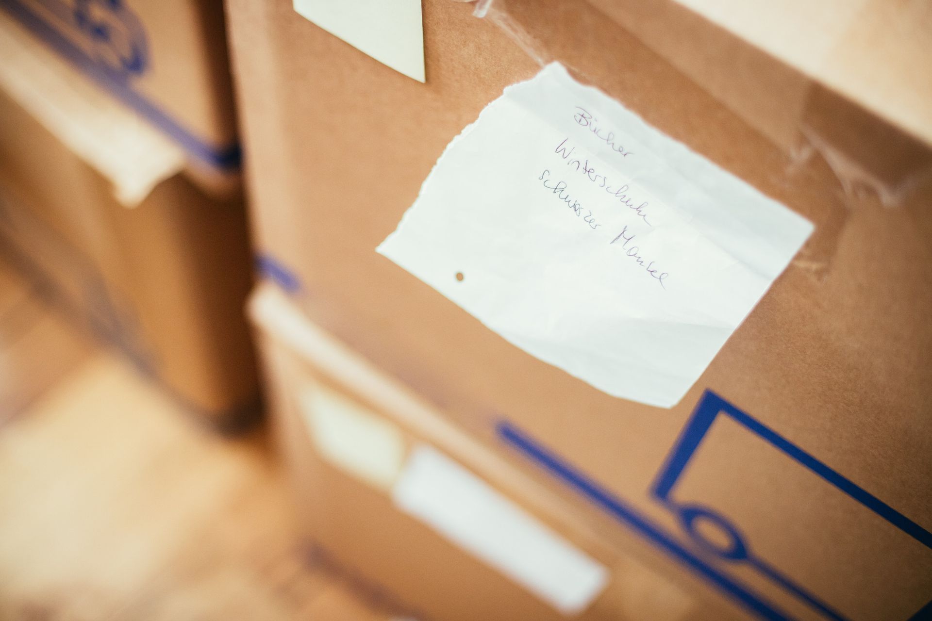 Cajas de cartón apiladas, con etiquetas escritas a mano.