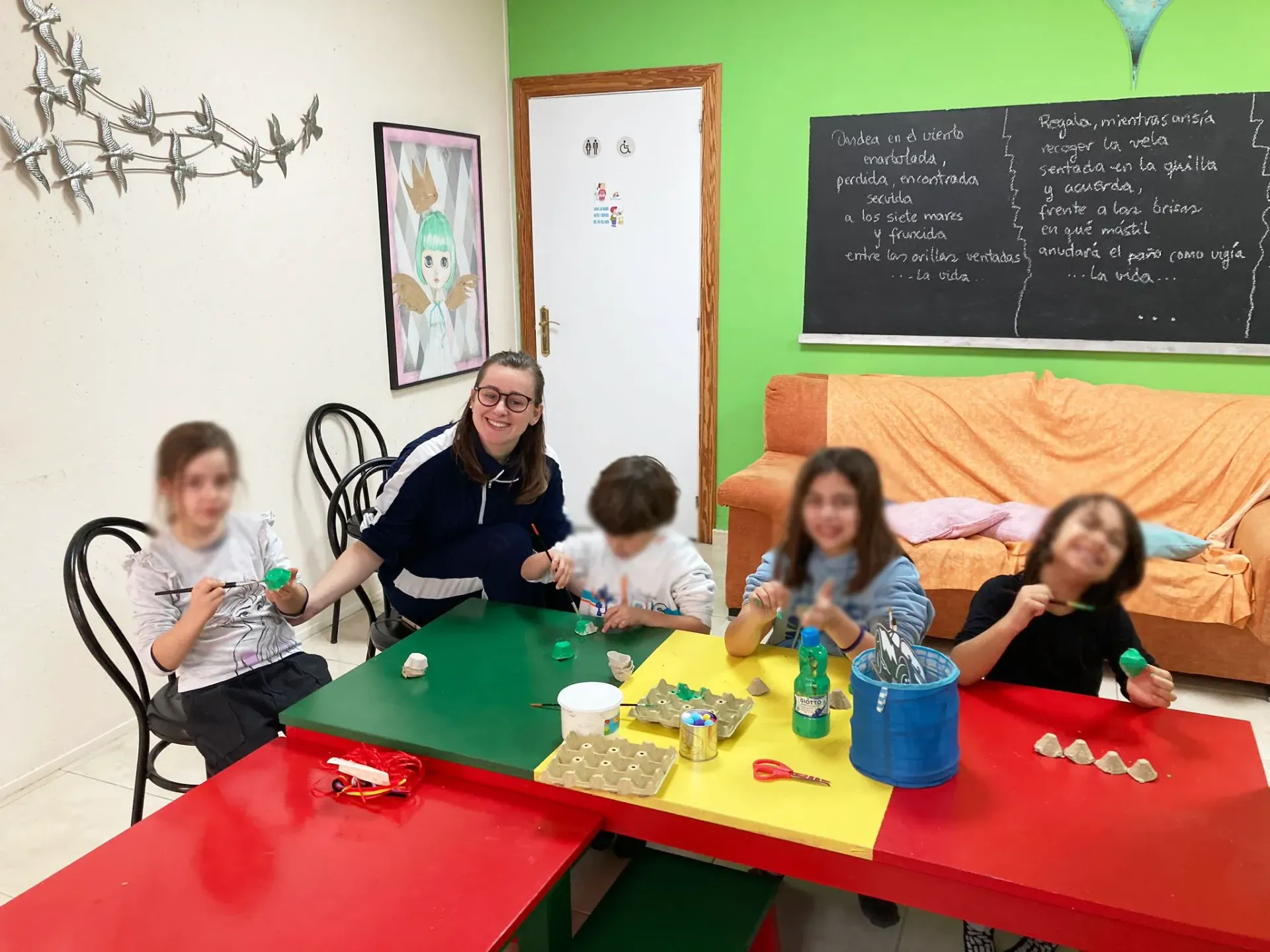 Un grupo de niños está sentado en una mesa en una habitación.