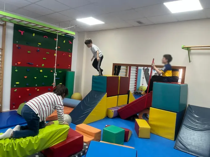 Un grupo de niños está jugando en un gimnasio.