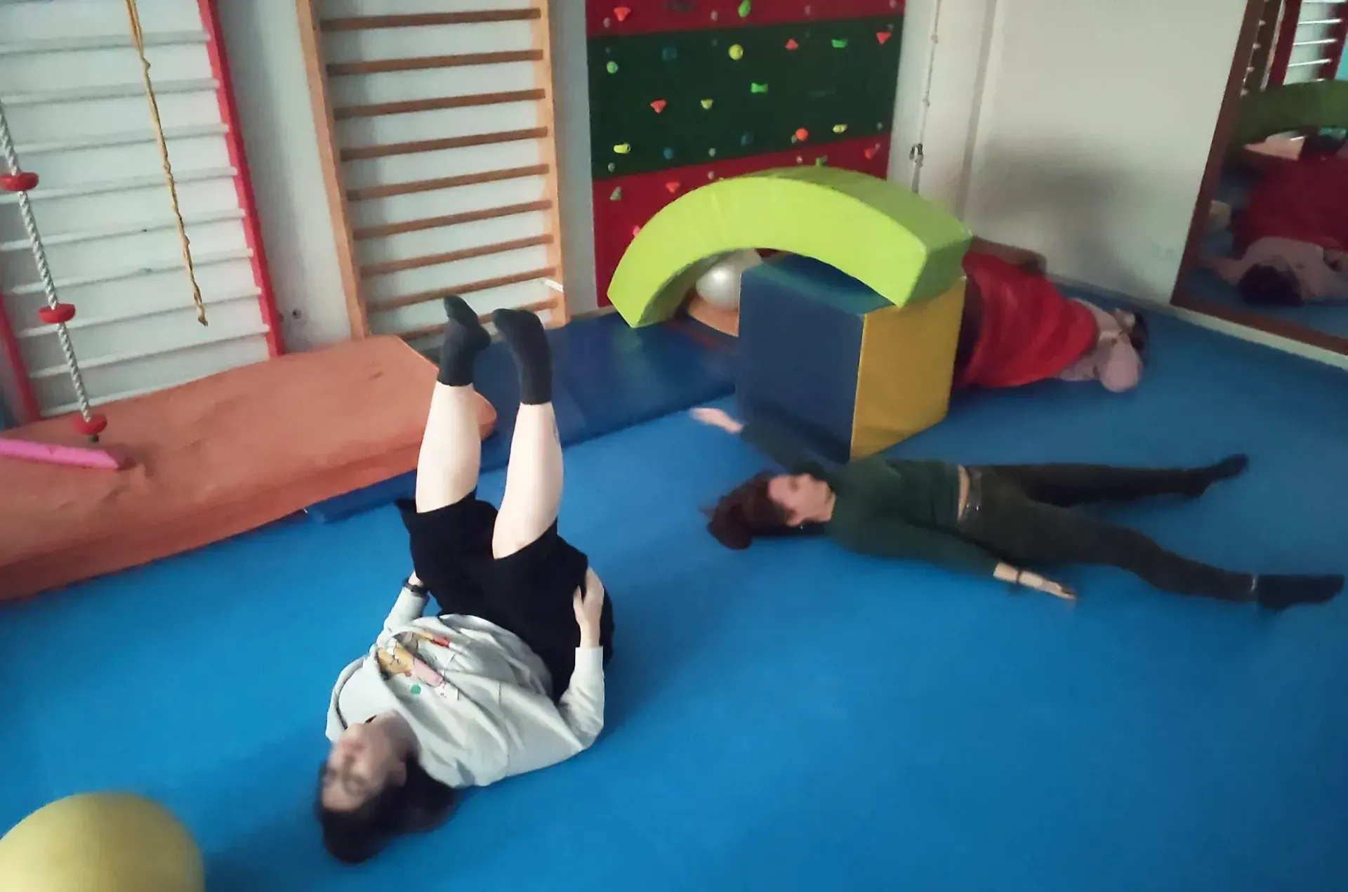 Un grupo de personas están tumbadas en el suelo en un gimnasio.