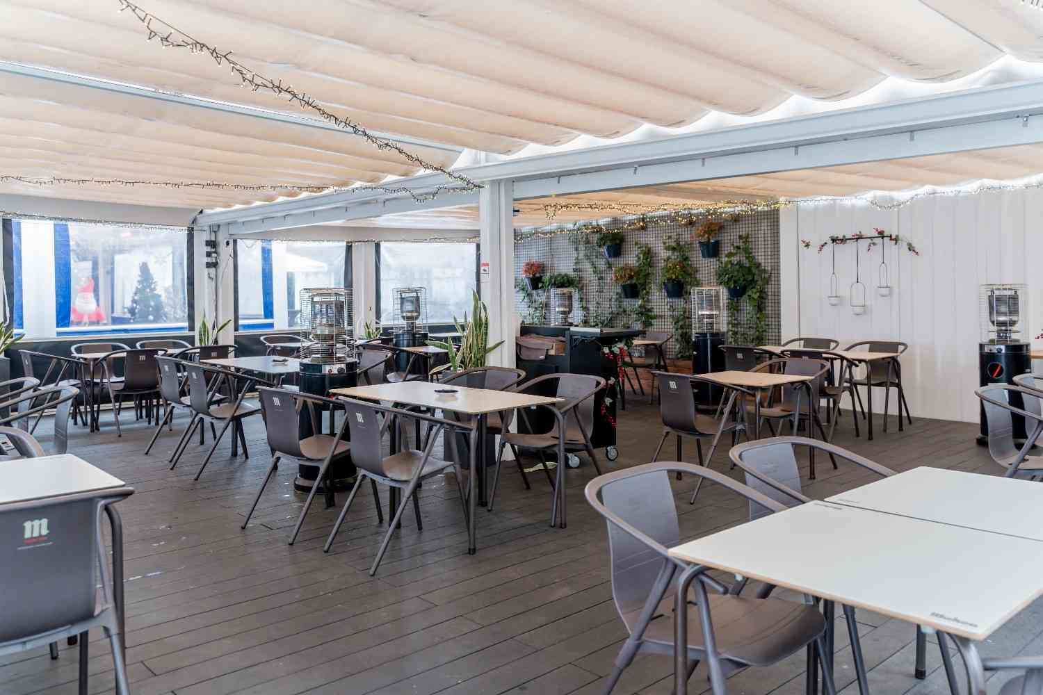 Mujer colocando una servilleta enrollada en un plato en una mesa preparada para cenar.