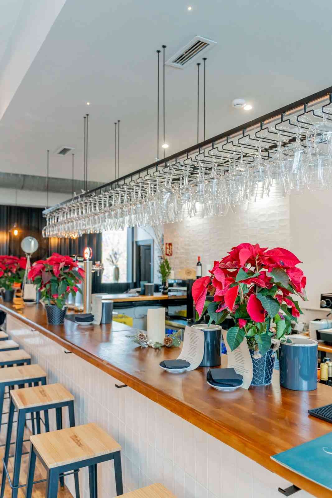Mujer colocando una servilleta enrollada en un plato en una mesa preparada para cenar.
