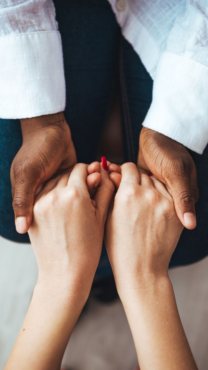 Deux personnes se tiennent la main en geste de soutien.