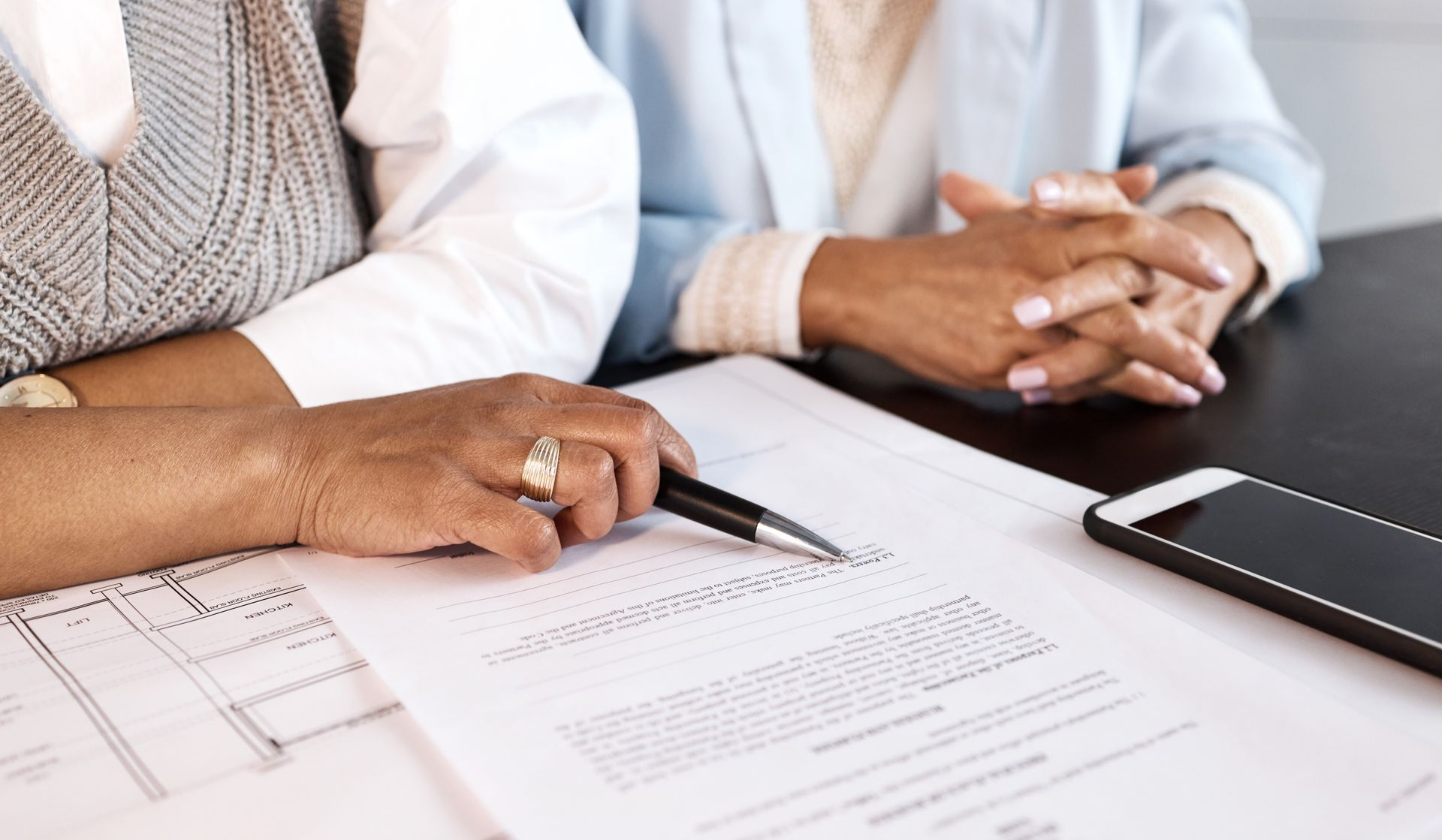 Deux personnes assises à une table examinent des documents administratifs.