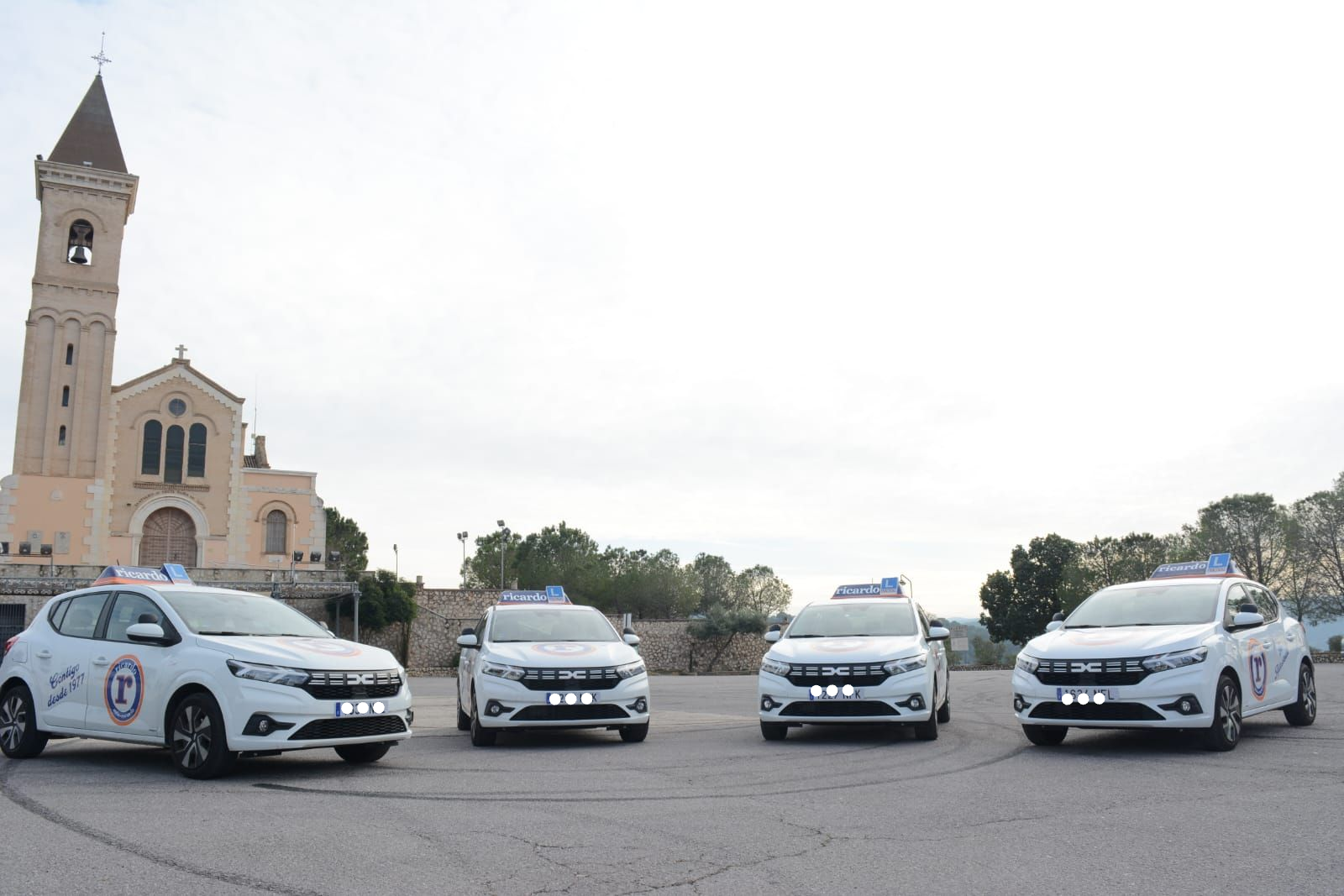 Cuatro coches blancos con carteles en forma de 