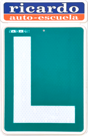 Laboratorio de informática con varias computadoras, escritorios y sillas. Paredes blancas, puerta roja e iluminación fluorescente.